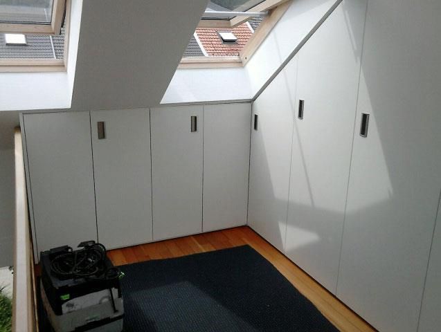 Ein Zimmer mit weißen Schränken und einem schwarzen Teppich