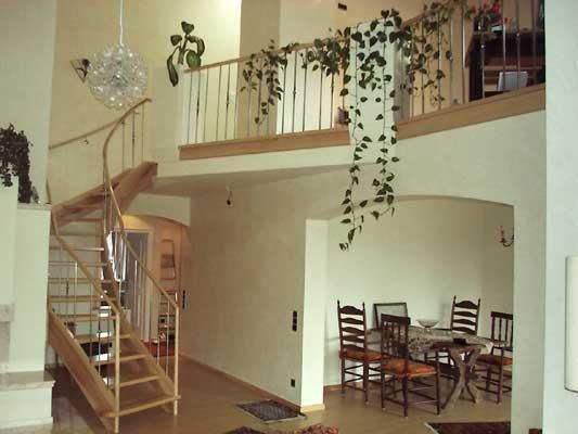 Ein Wohnzimmer mit einer Wendeltreppe in den zweiten Stock