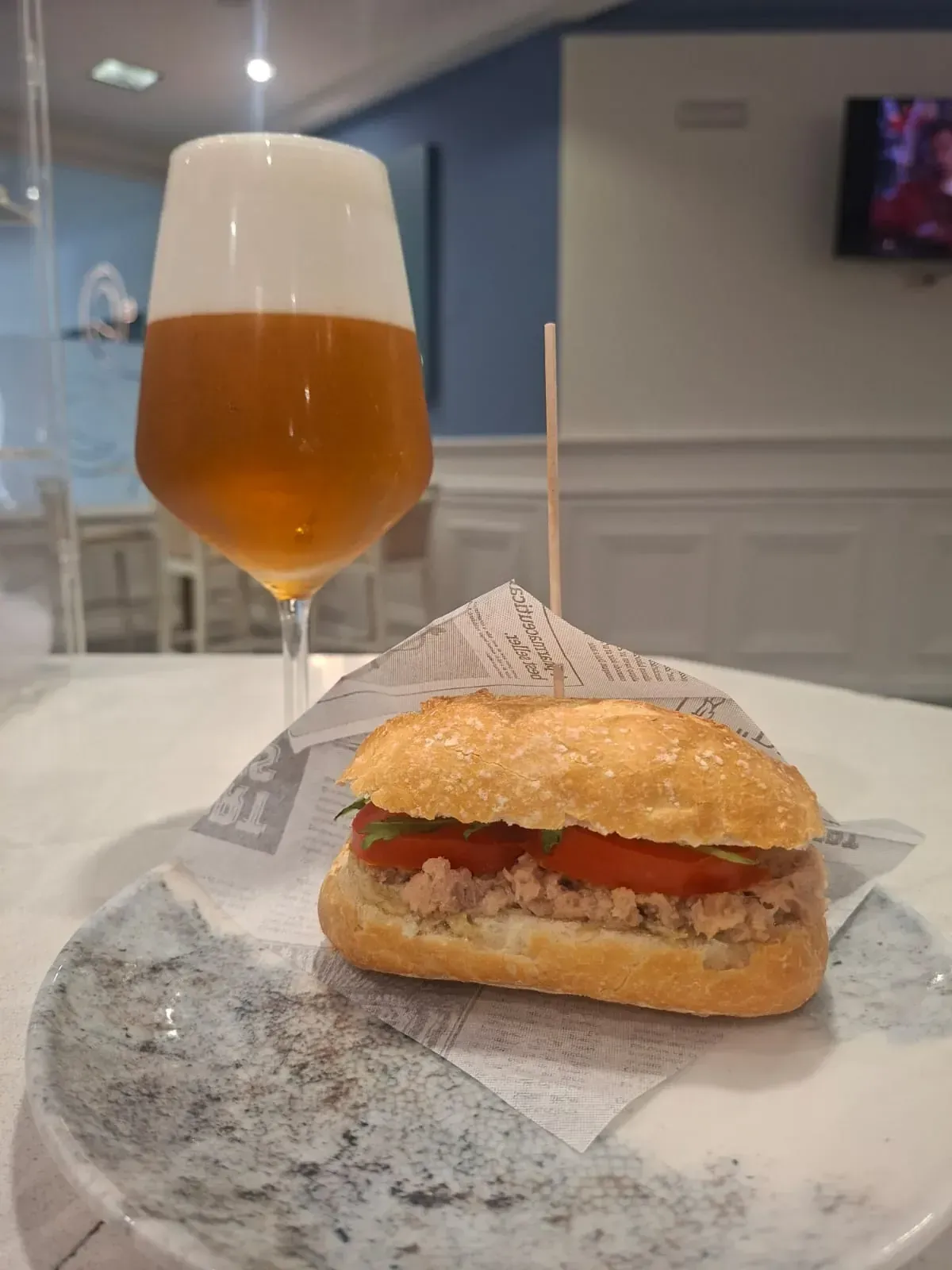 Hamburguesa y cerveza sobre una mesa en el comedor de un restaurante.