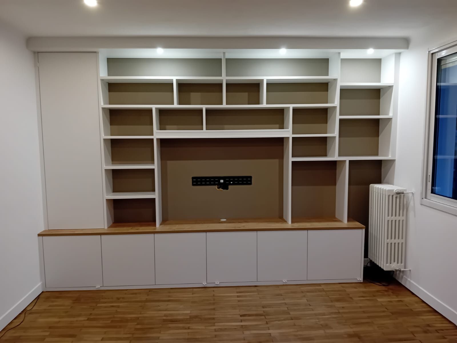 Bibliothèque sur mesure à Nantes avec emplacement TV et spot LED.