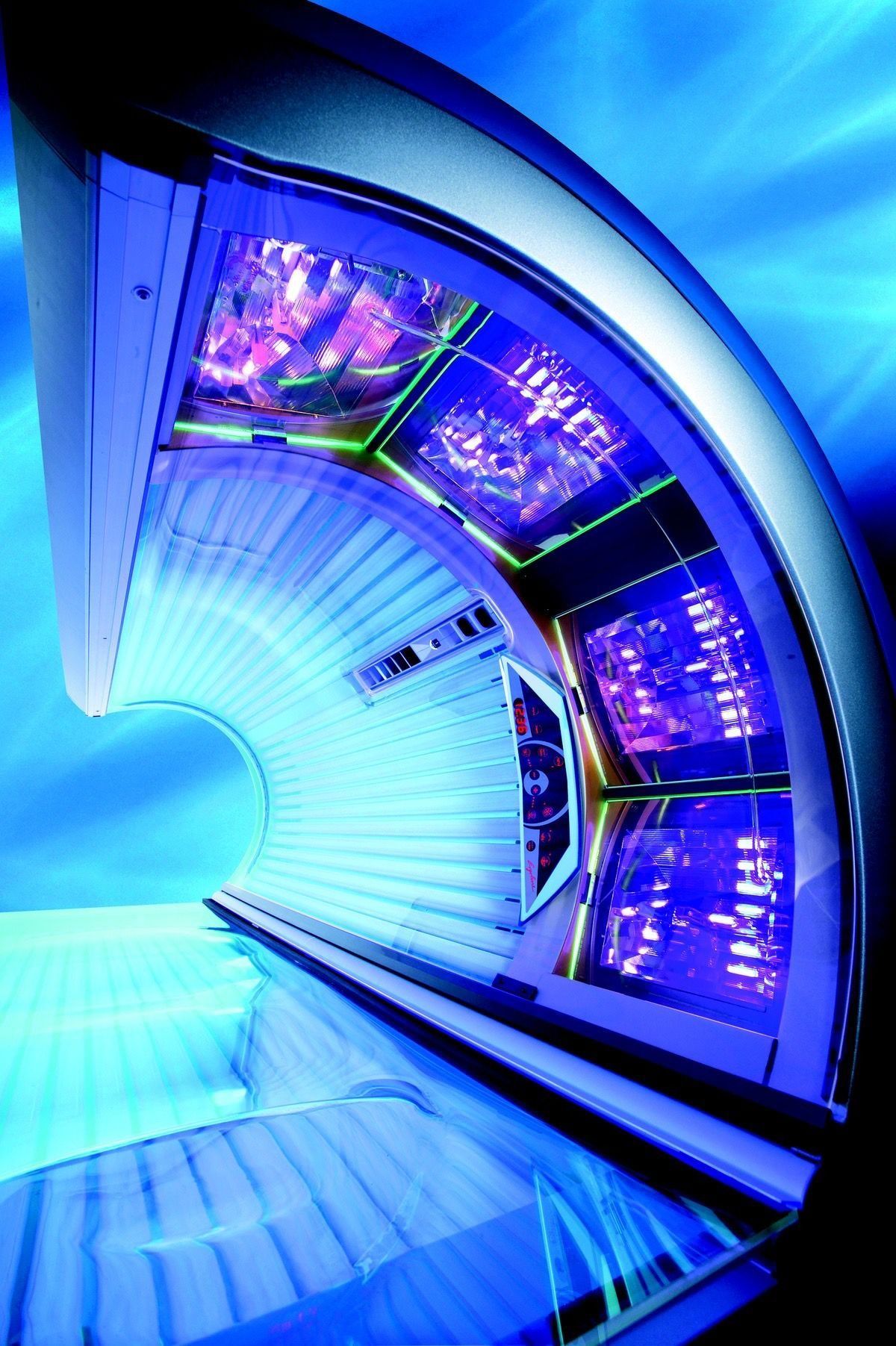 Una cabina de bronceado abierta con luces ultravioleta azules brillantes, vista desde una perspectiva interior.