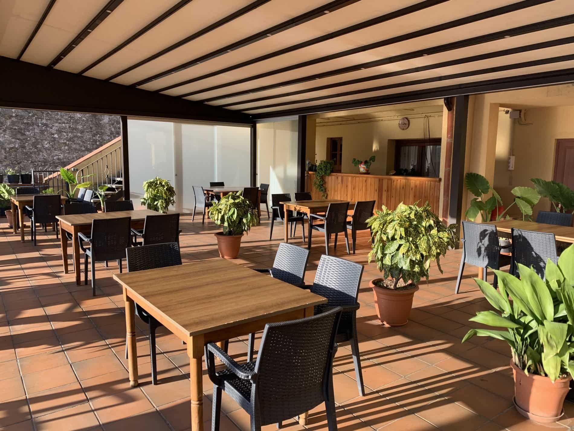 Un restaurant amb taules i cadires i plantes en test