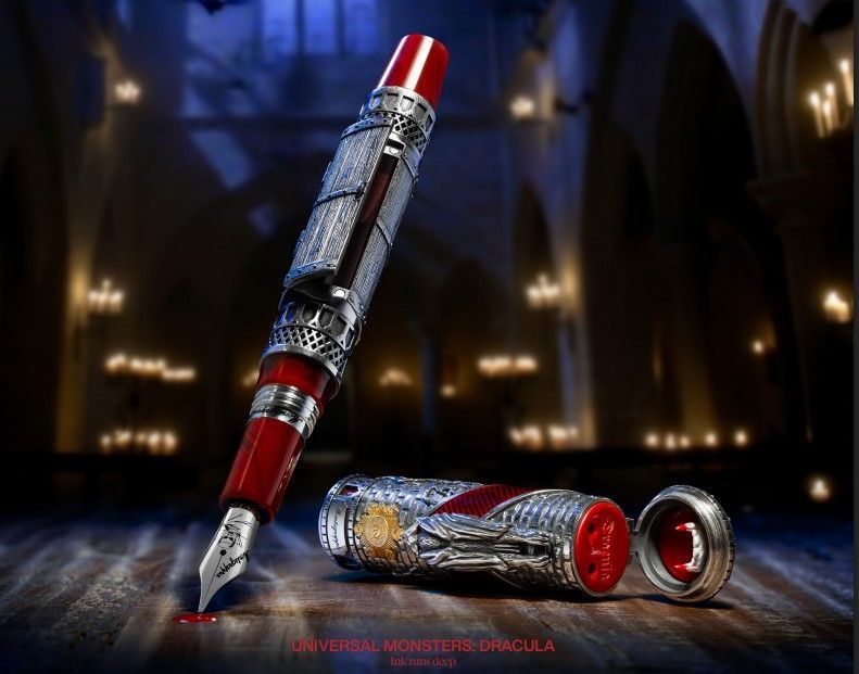 Una pluma estilográfica Montblanc Dracula con intrincados grabados en plata y detalles rojos, sobre un suelo oscuro iluminado por velas.