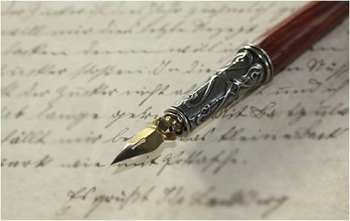 Una pluma estilográfica está encima de un trozo de escritura a mano.