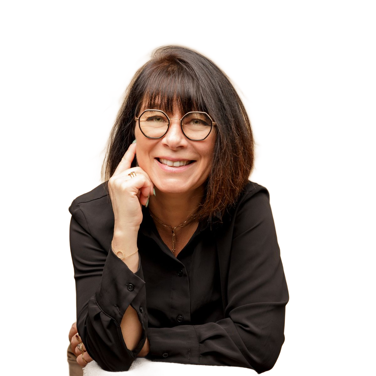 Femme souriante portant des lunettes et des cheveux foncés, le menton appuyé sur sa main, sur fond blanc.