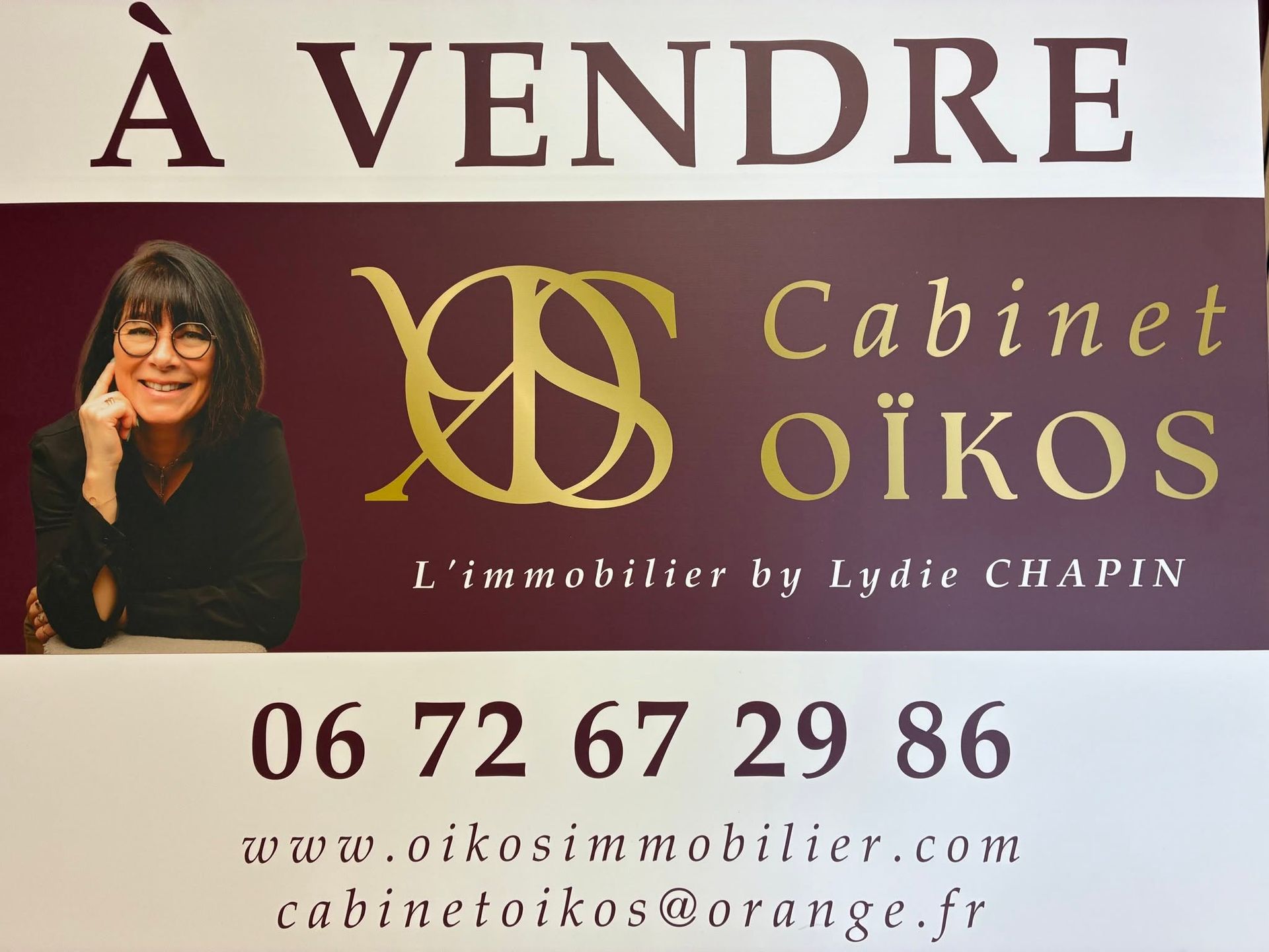 À vendre : carte de Cabinet OÏKOS immobilier, fond bordeaux, photo d’une femme, téléphone et site web visibles