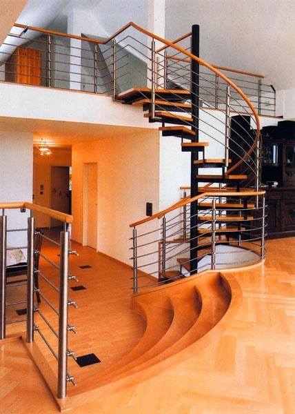 Wendeltreppe aus Holz mit Metallgeländer in einem modernen Haus.