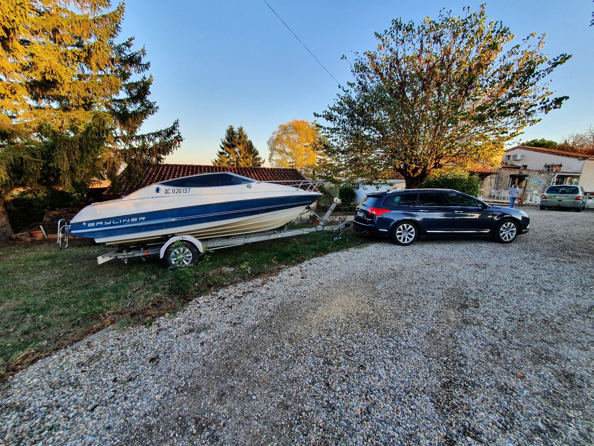 Un bateau sur une remorque, tracté par une voiture.