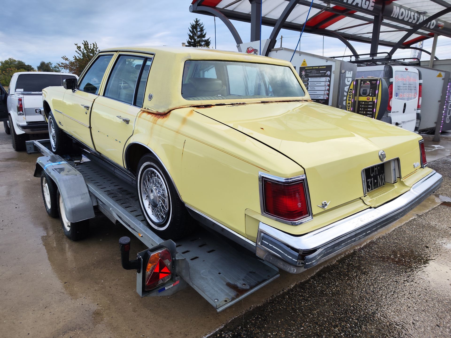 Vue arrière d'une Cadillac Sévilel jaune sur une remorque.