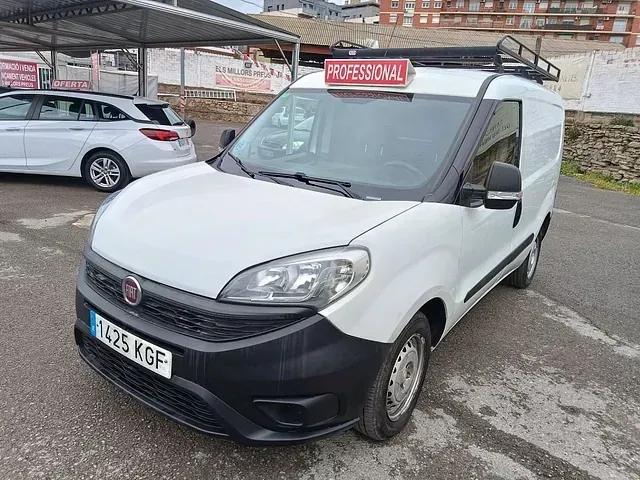 Una camioneta blanca está estacionada en un estacionamiento al lado de un automóvil blanco.