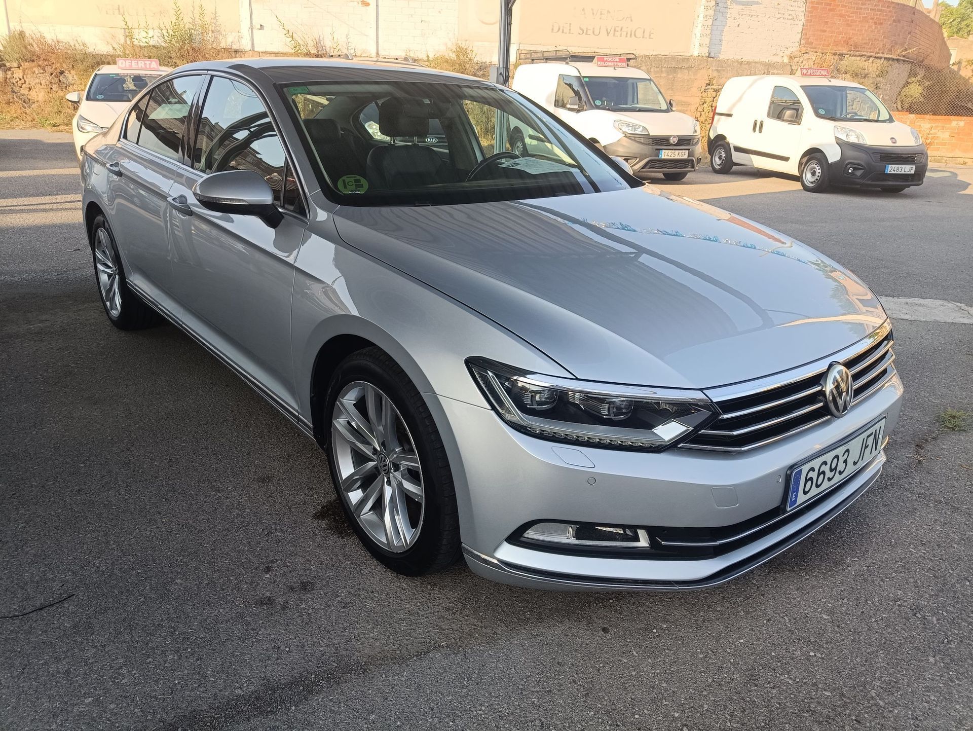 Un coche Opel blanco está aparcado delante de un edificio de ladrillo.