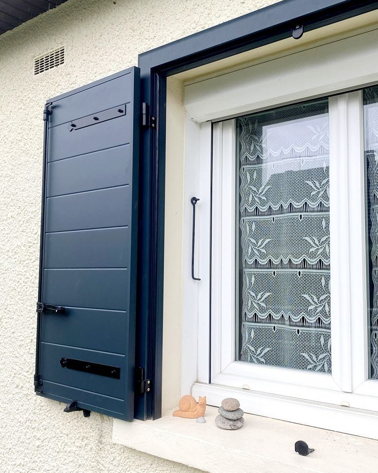 Volets battants foncés et fenêtre blanche