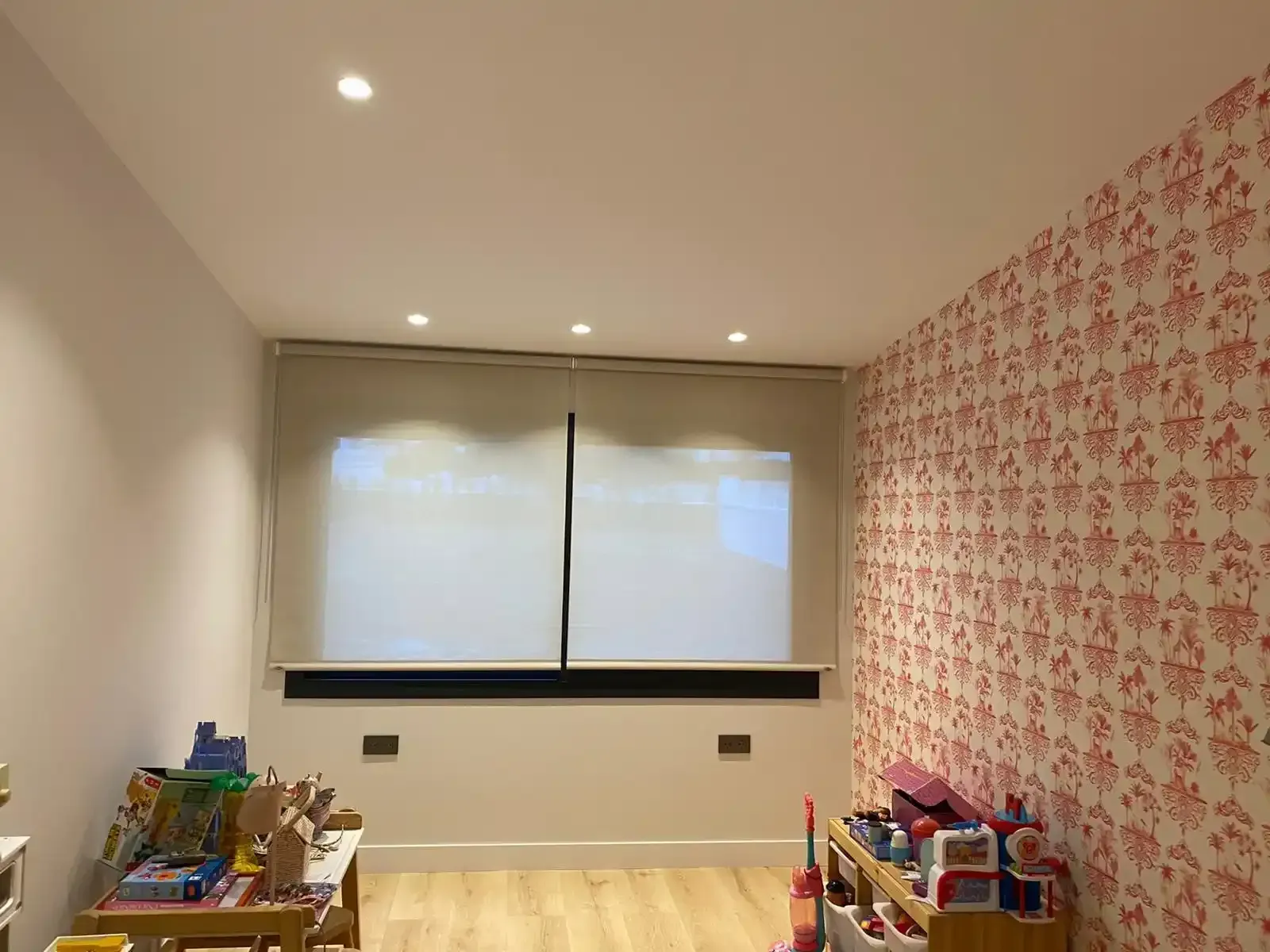 Una habitación con muchos juguetes y una ventana con persianas.