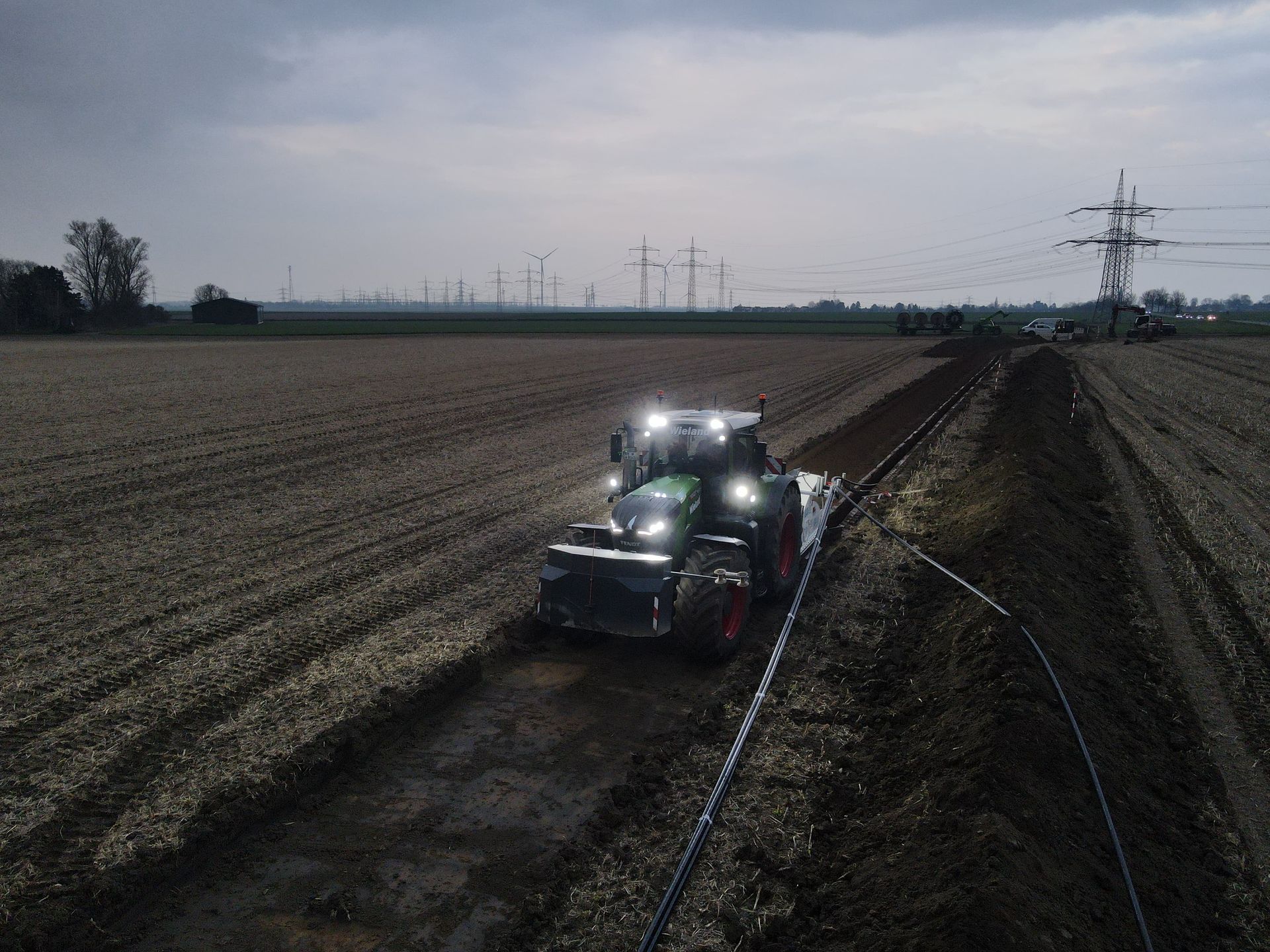 Ein Traktor pflügt nachts ein Feld