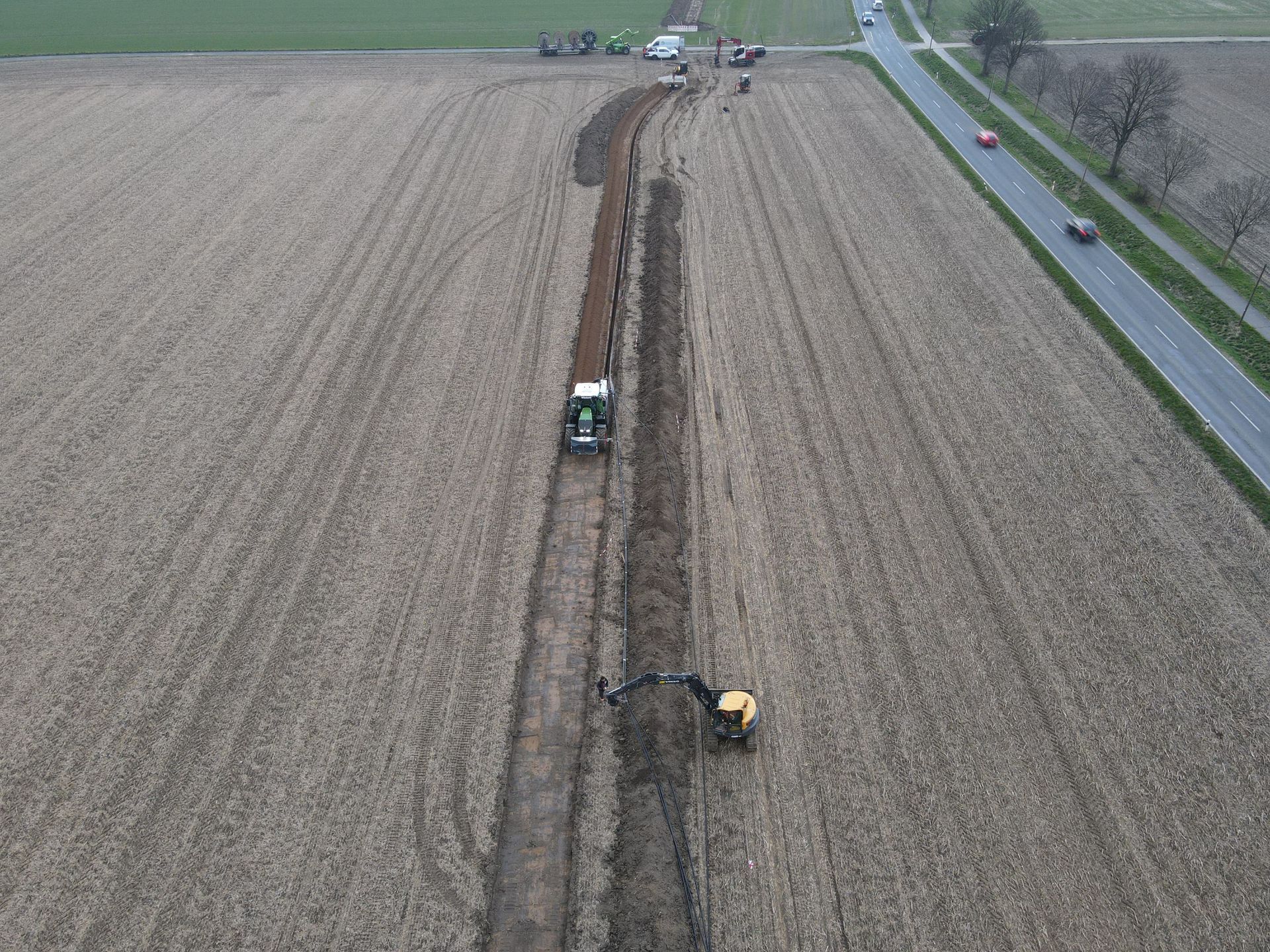 Eine Luftaufnahme eines Traktors, der ein Feld neben einer Straße pflügt