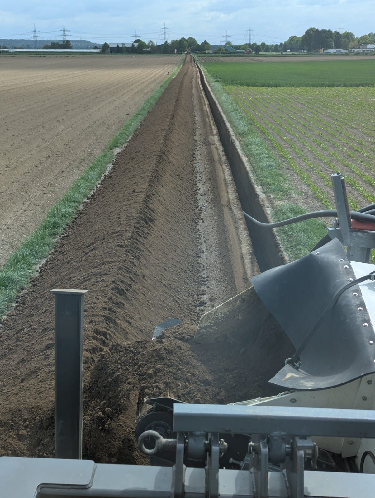 Eine Maschine pflügt ein Feld aus Erde und Gras