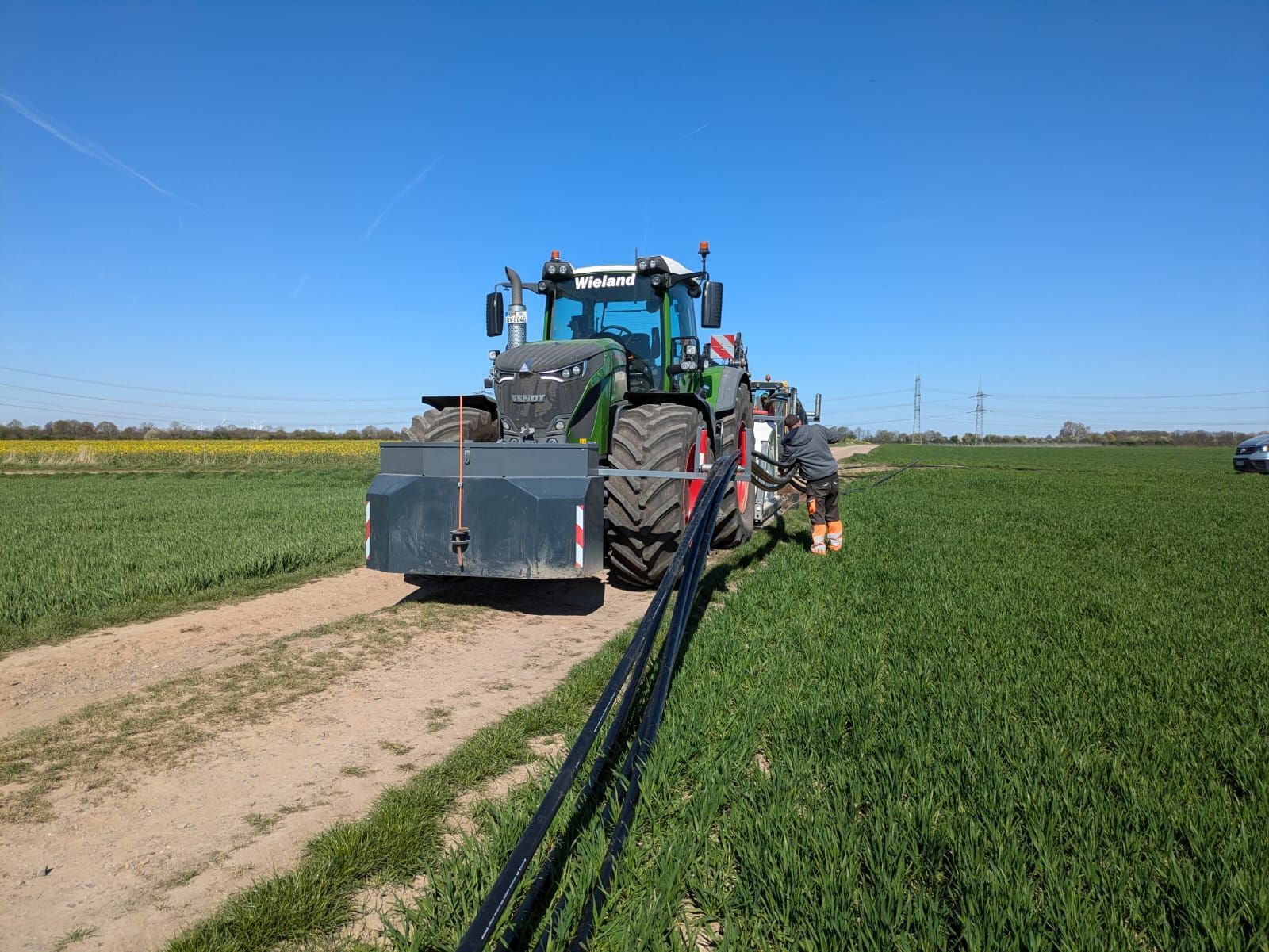 Ein Traktor fährt einen Feldweg entlang