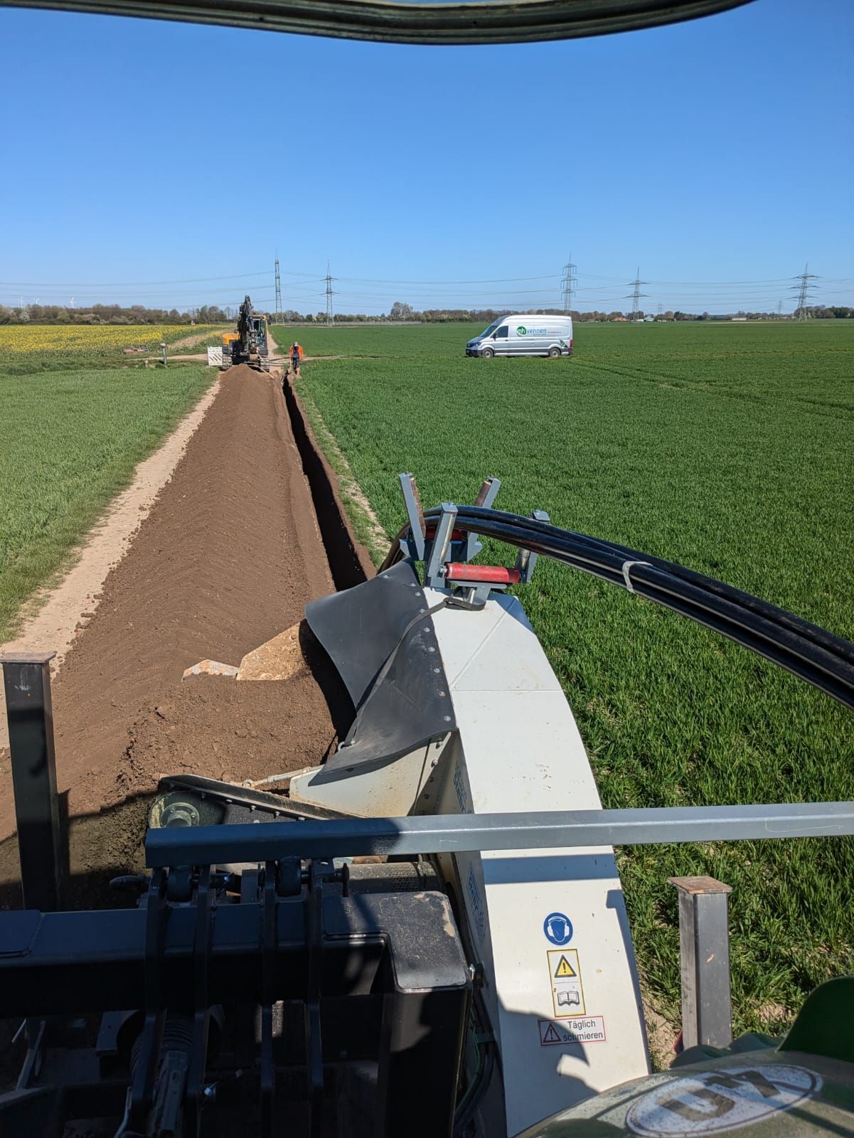 Ein Traktor gräbt einen Graben auf einem Feld