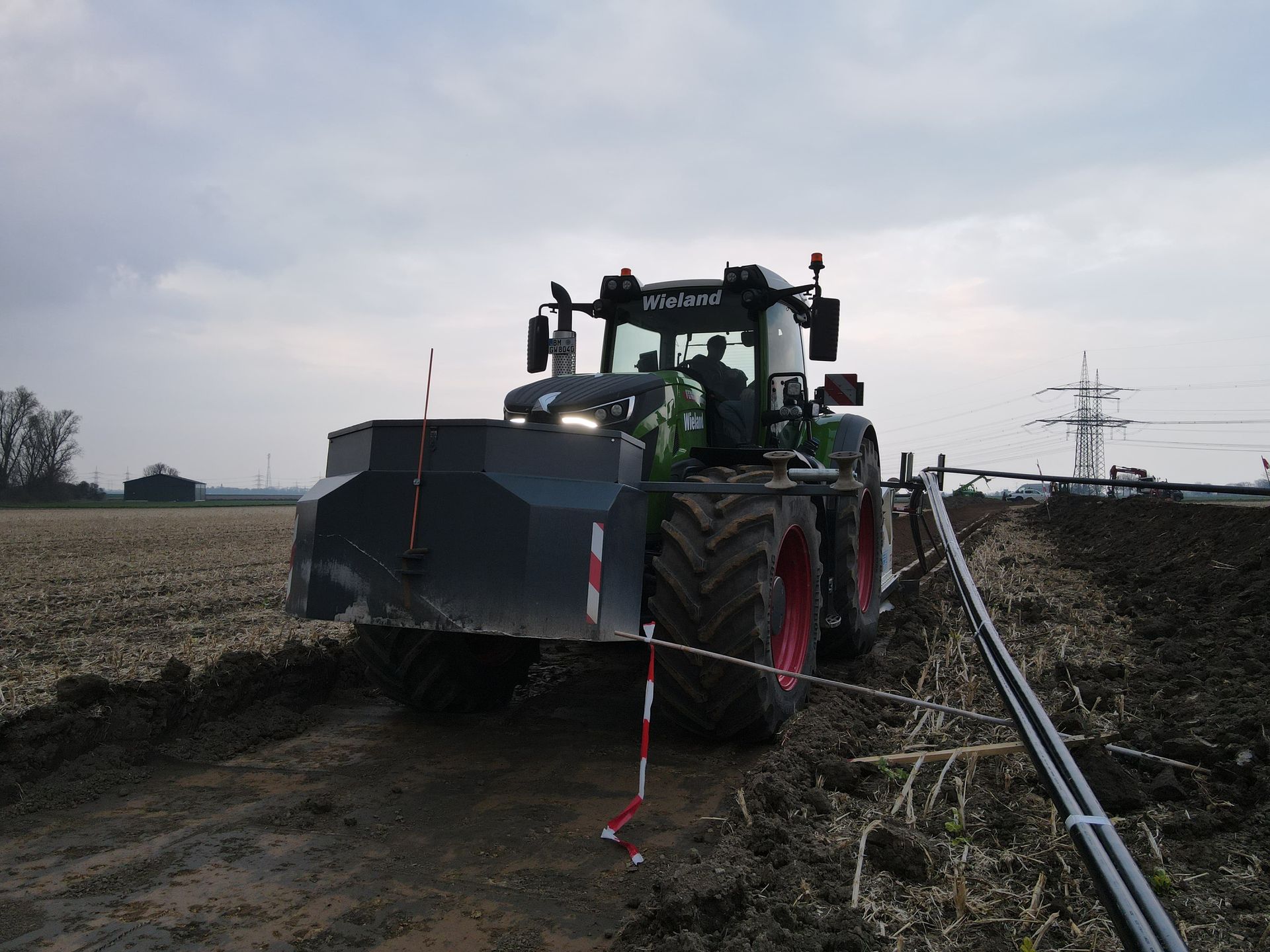 Ein schwarz-grüner Traktor steht auf einem Feld