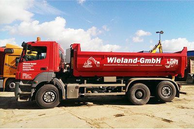 Ein roter Sattelschlepper steht auf einem Parkplatz.