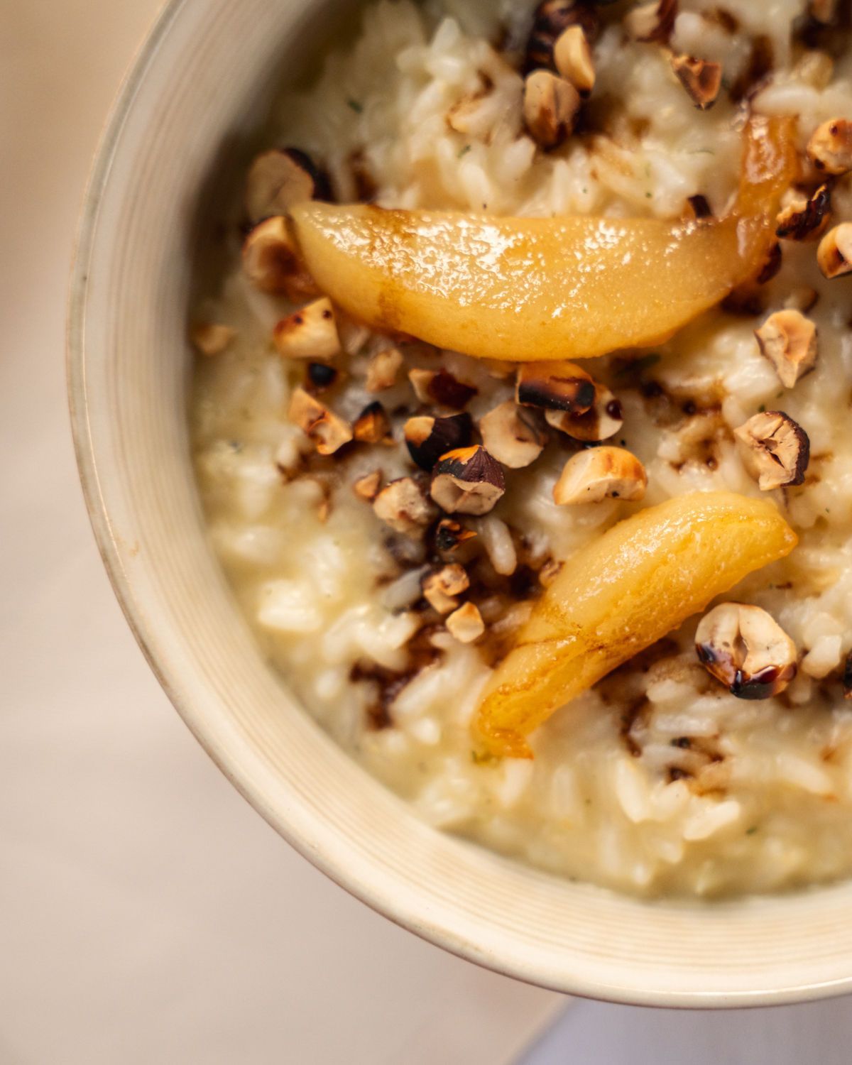Schüssel mit cremigem Haferbrei, garniert mit Granola und Pfirsichscheiben