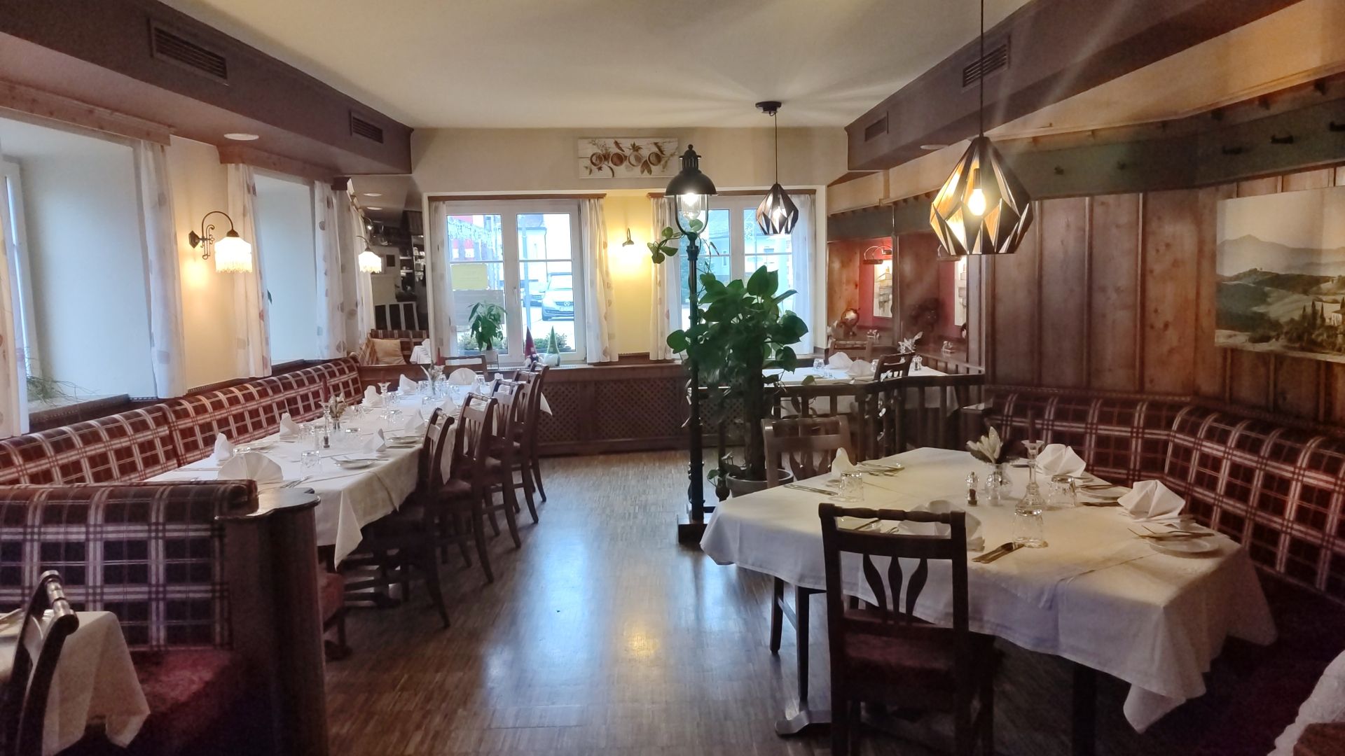 Restaurant-Innenraum mit gedeckten Tischen, rotem und hölzernem Dekor.