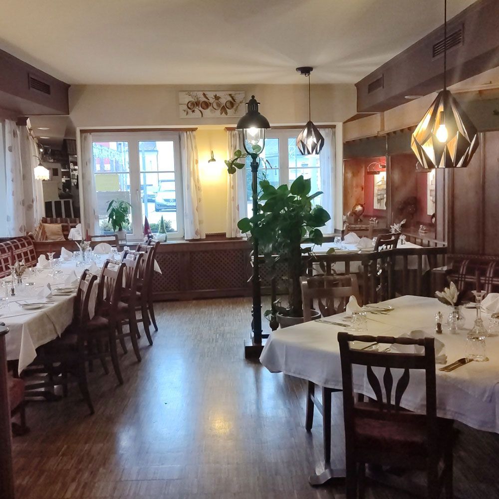 Restaurant-Innenraum mit langen, gedeckten Tischen und einer dekorativen Straßenlaterne.