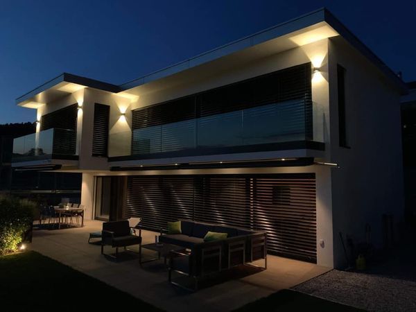 Ein Haus ist nachts beleuchtet und hat einen Balkon