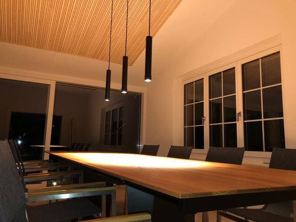 Ein Esszimmer mit einem langen Holztisch und Stühlen