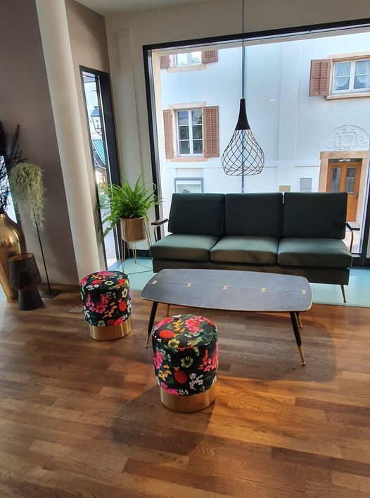 Ein Wohnzimmer mit Sofa, Couchtisch und Ottomanen.