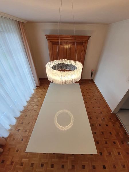 Ein Esstisch mit einem Kronleuchter, der von der Decke hängt