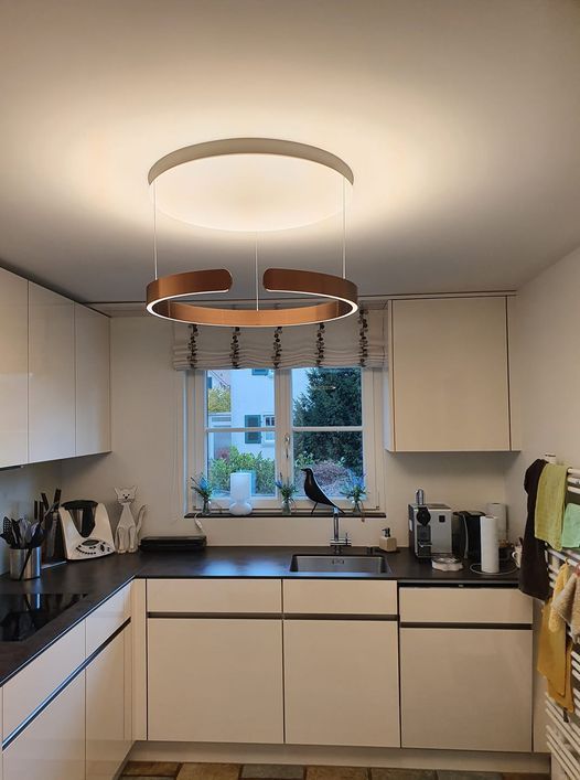 Eine Küche mit weißen Schränken, einer Spüle und einer Deckenleuchte.