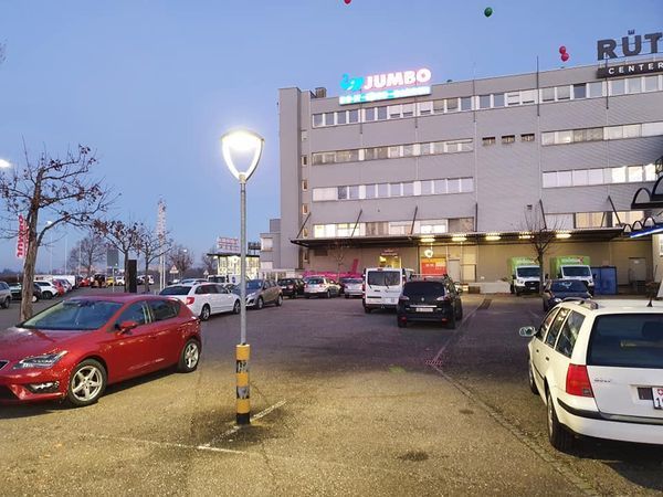 Viele Autos parken vor einem Gebäude mit der Aufschrift „Jumbo“