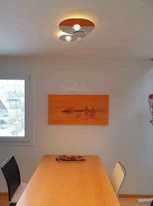 Ein Esstisch mit einem Gemälde an der Wand darüber