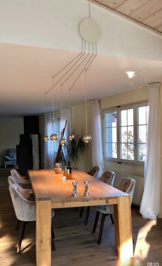 Ein Esszimmer mit einem langen Holztisch und Stühlen.