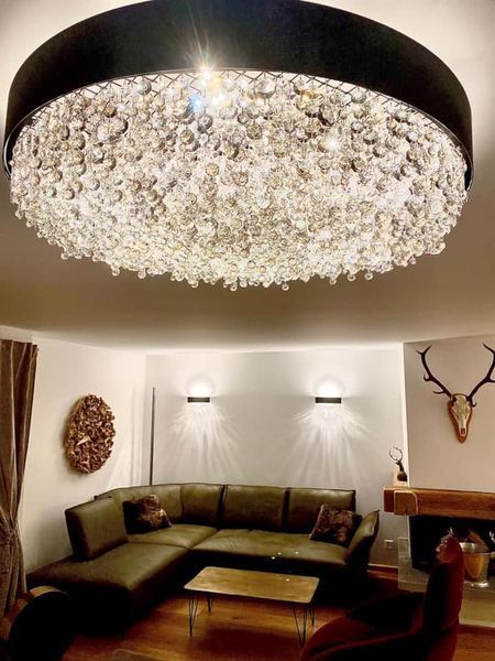 Ein Wohnzimmer mit einer Couch und einem großen Kronleuchter, der von der Decke hängt.