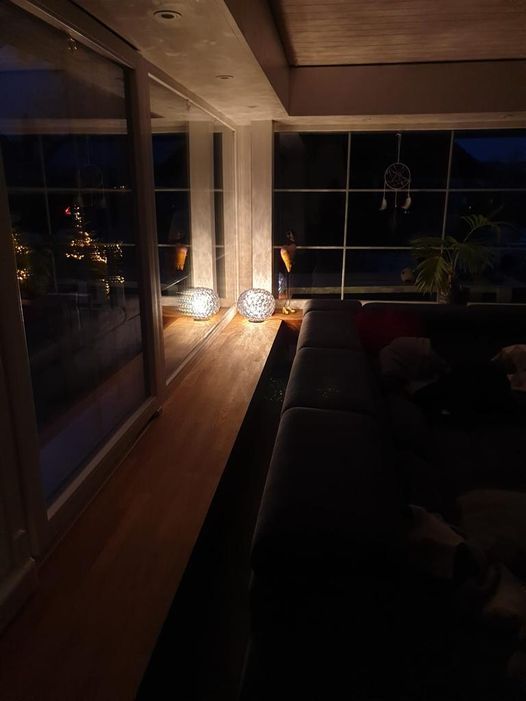 Ein Wohnzimmer mit einer Couch und einem Fenster bei Nacht