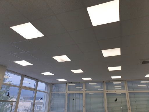 Ein Raum mit vielen Fenstern und quadratischen Lichtern an der Decke.