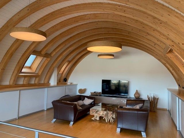 Ein Wohnzimmer mit gewölbter Decke und einer Couch und Stühlen