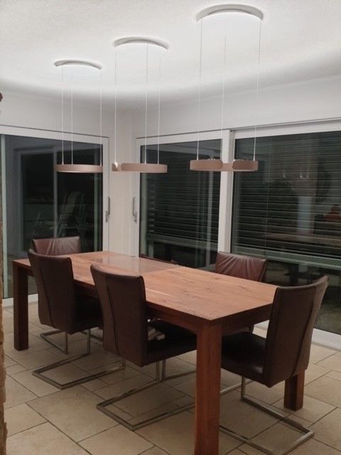 Ein Esszimmer mit einem Holztisch und Stühlen