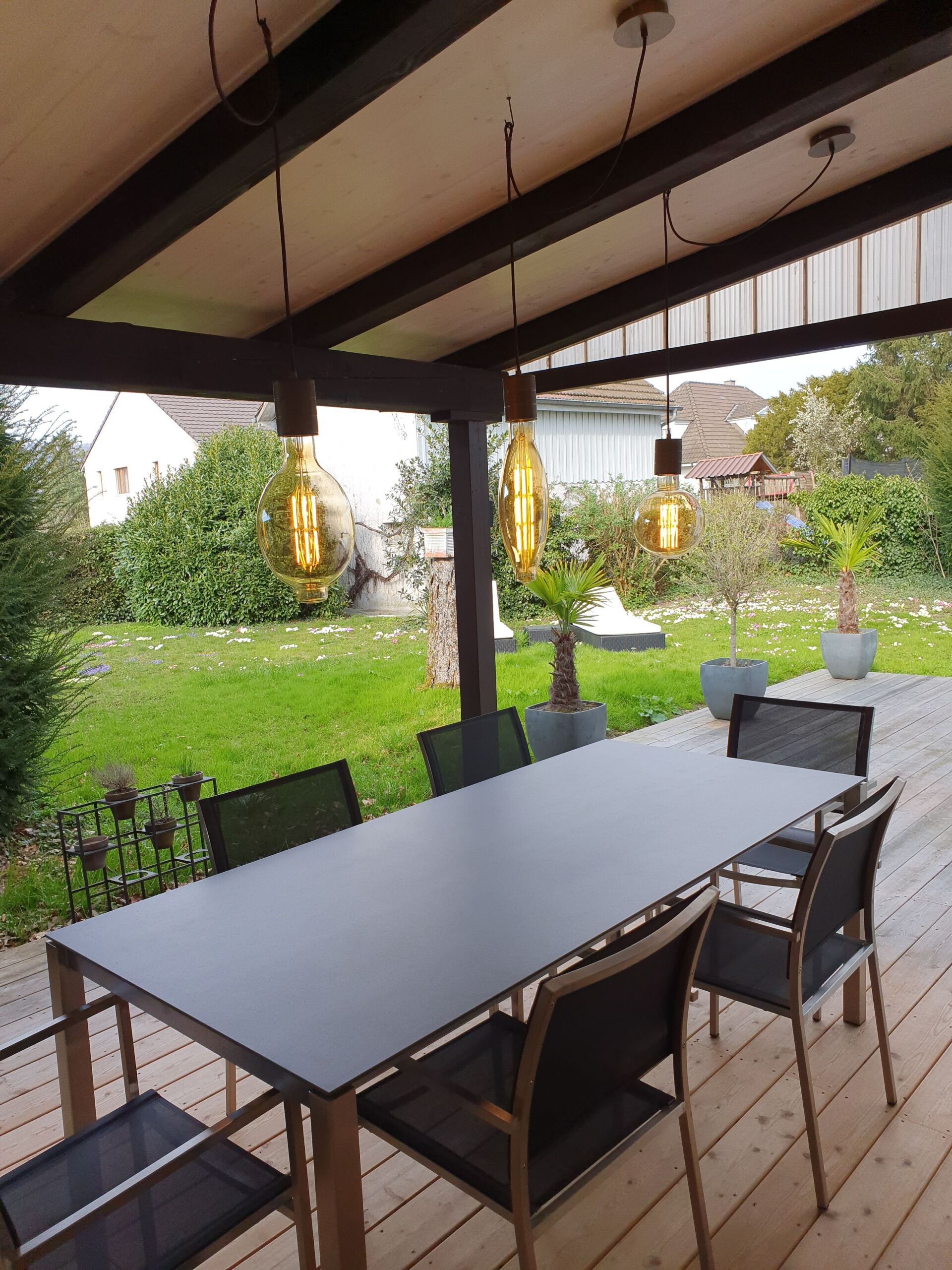 Eine Terrasse mit Tisch und Stühlen unter einem Baldachin