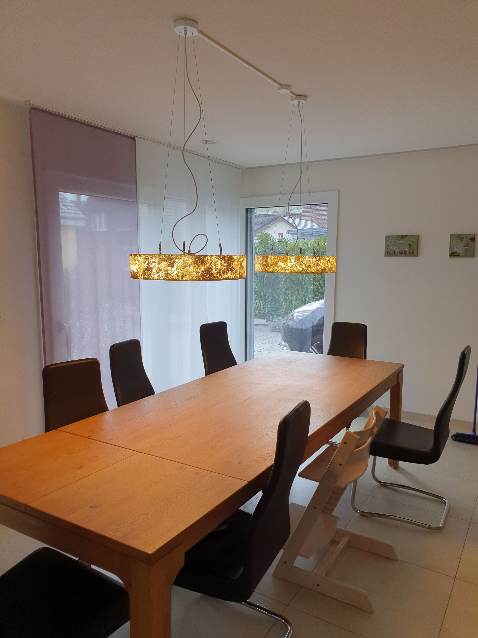 Ein Esszimmer mit einem langen Holztisch und Stühlen