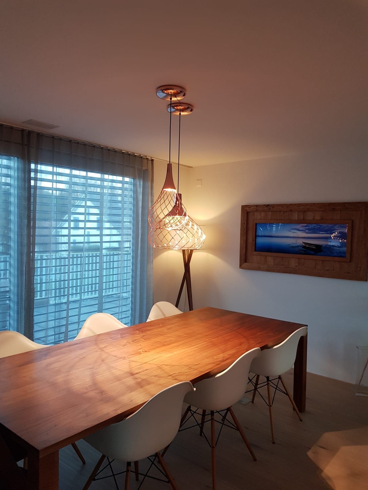 Ein Esszimmer mit einem Holztisch und weißen Stühlen