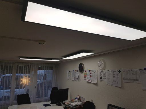 Ein Raum mit einer Uhr an der Wand und einer Uhr an der Decke.