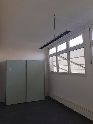 Ein leerer Raum mit vielen Fenstern und einer Deckenleuchte.