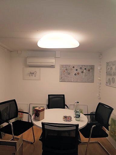 Ein kleiner Konferenzraum mit rundem Tisch und Stühlen.