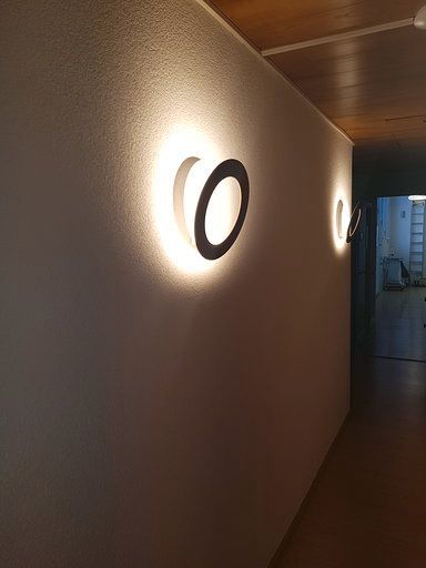 Ein Flur mit zwei Lichtern an der Wand und einer Tür im Hintergrund.