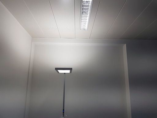 In der ecke des zimmers steht eine lampe auf dem boden.