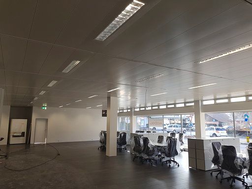 Ein großes leeres Büro mit vielen Fenstern und Stühlen.