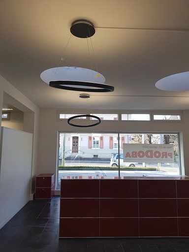 Ein Rezeptionsbereich mit rotem Tresen und großem Fenster.